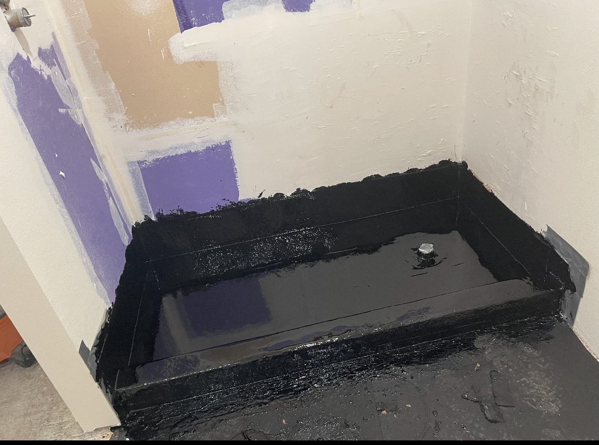 Completed black hot mop shower pan sealed and ready for tile.