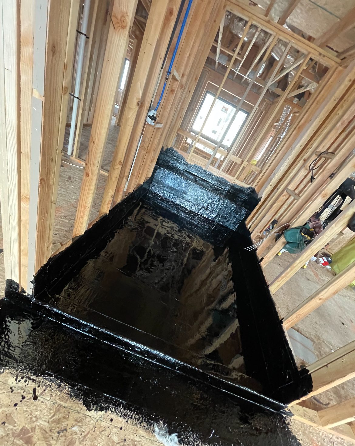 Sloped shower pan hot mopped for drainage, framed and ready for the next trade.
