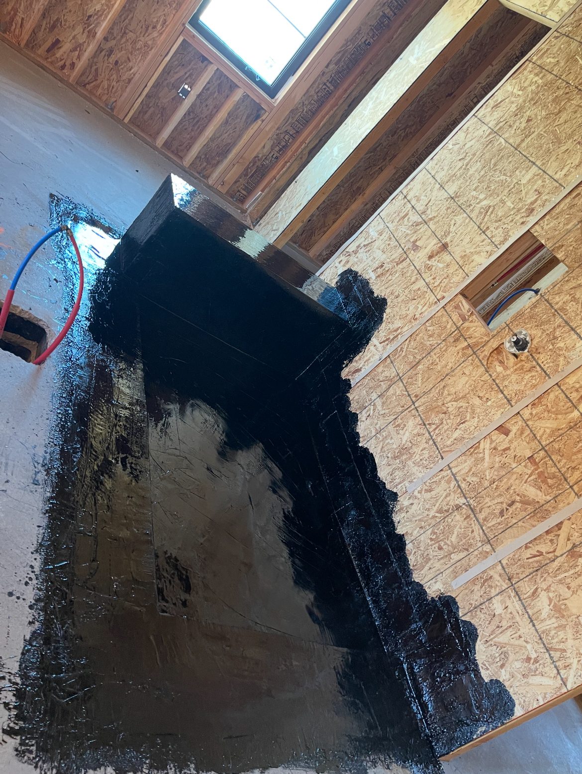 Interior floor and curb sealed with a black hot mop membrane during construction.